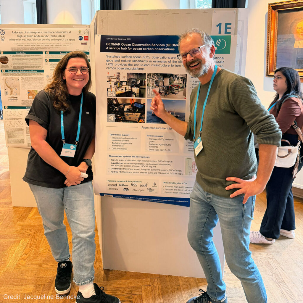 Louise Delaigue and Tobias Steinhoff posing next to a poster.